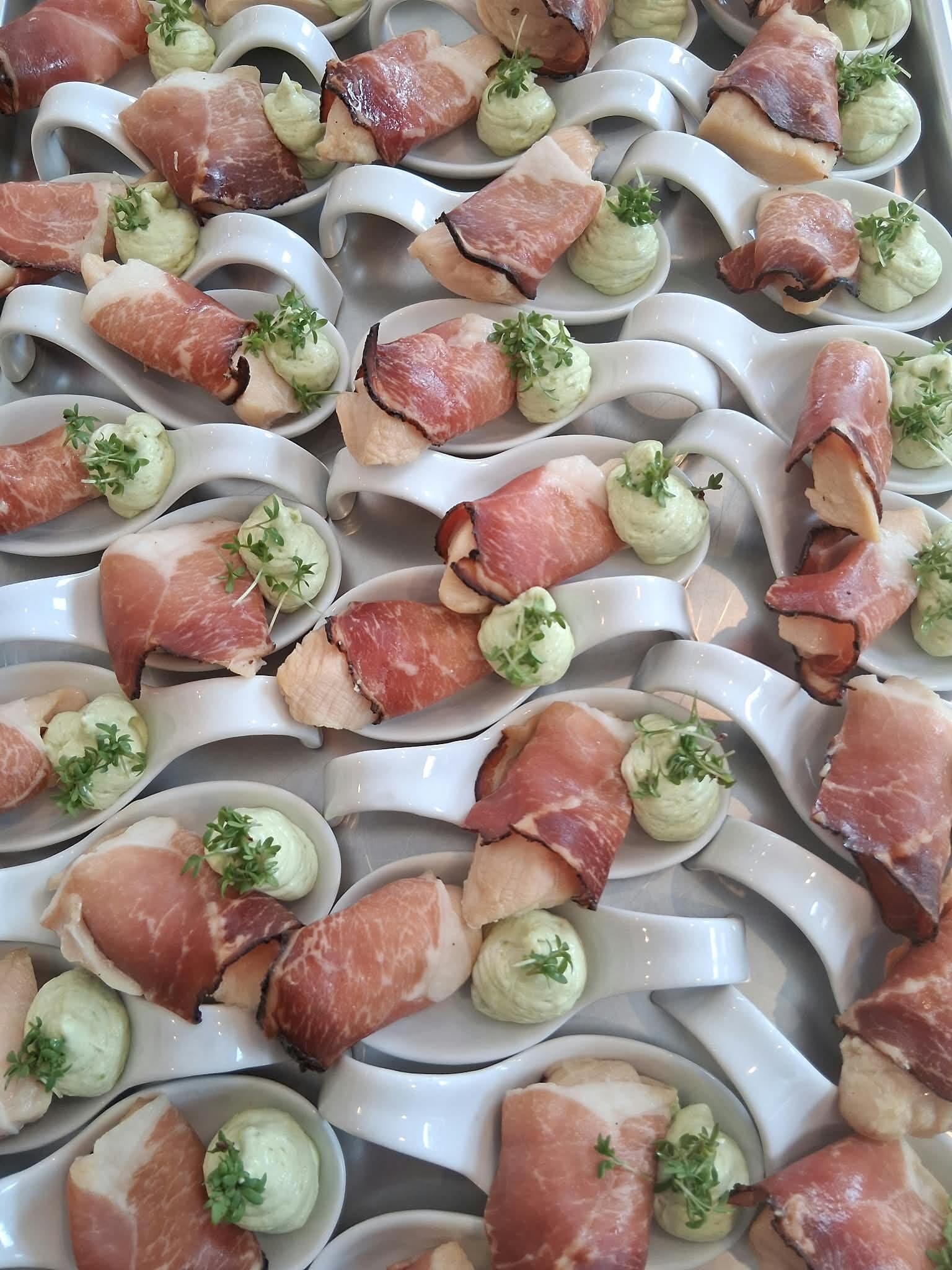 Löffel-Häppchen: Schinkenröllchen mit grüner Creme auf weissen Porzellanlöffeln