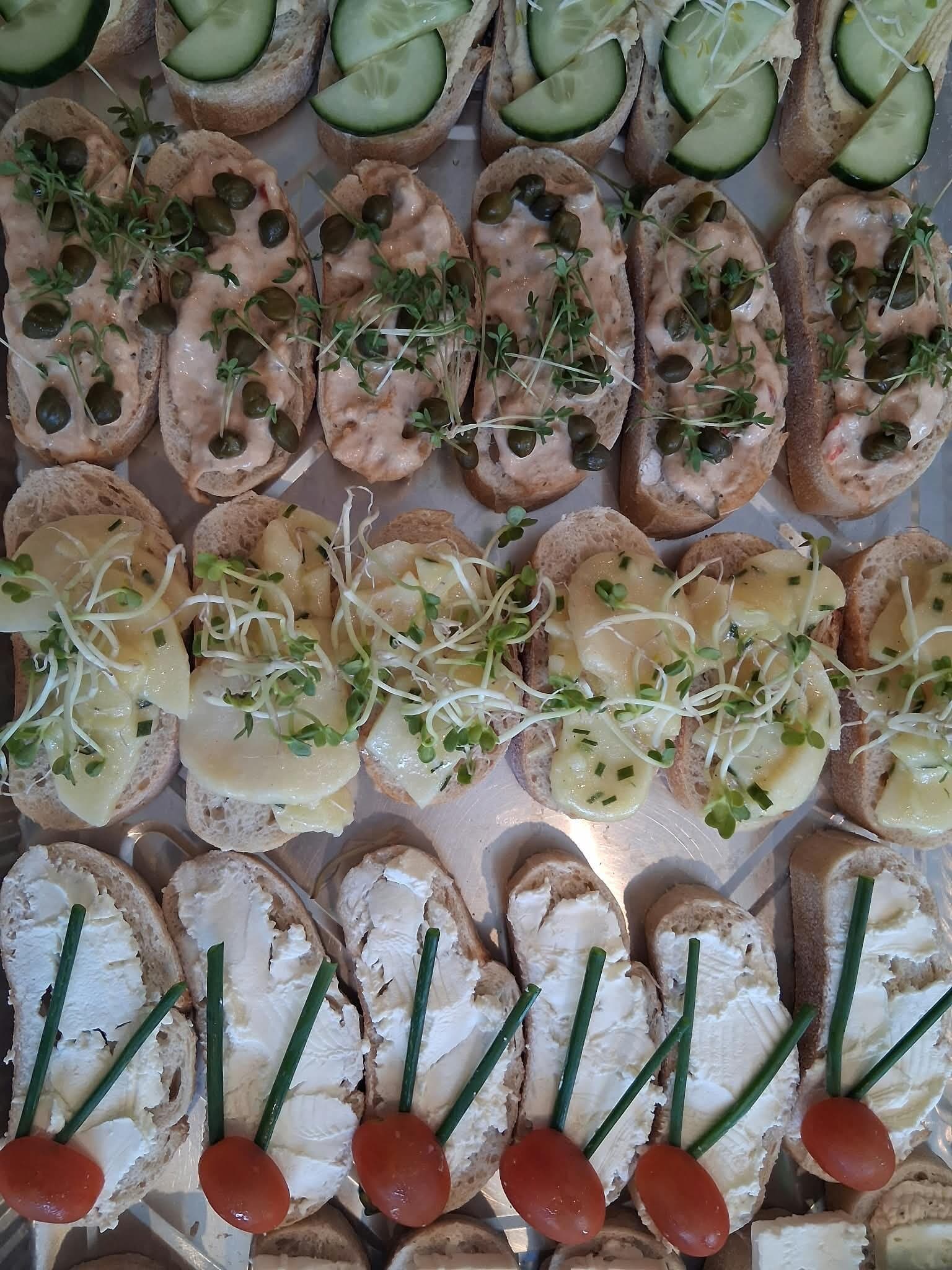 Tablett mit Canapés, Creme, Gurke und Kräutern