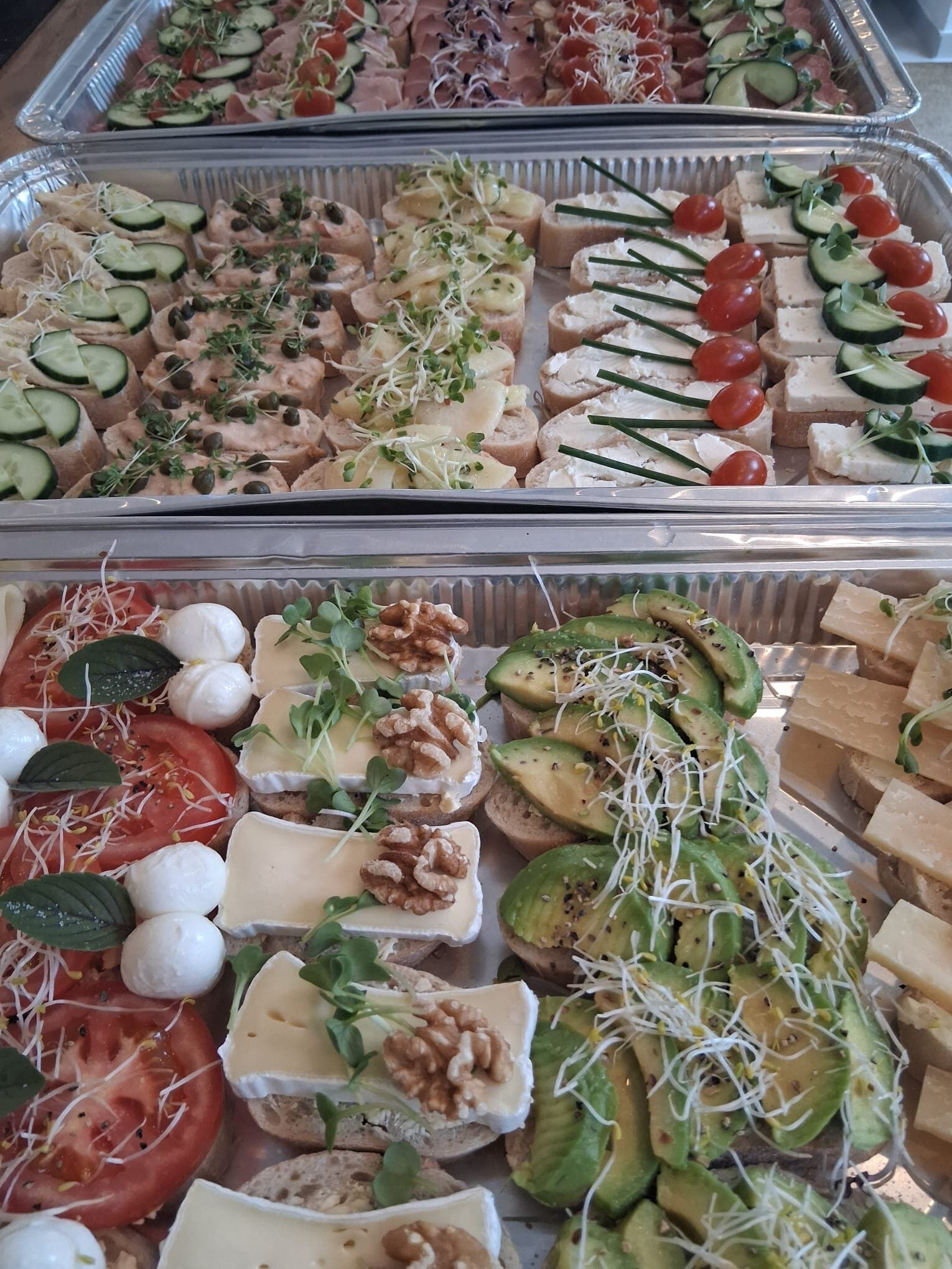 Mehrere Tabletts mit Canapés und Antipasti
