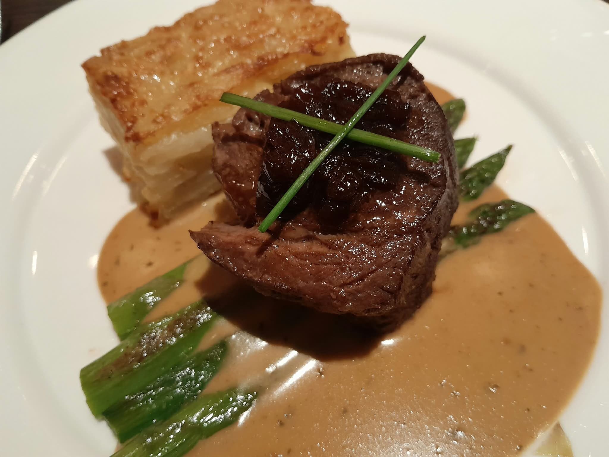 Fleisch mit dunkler Glasur, Kartoffelgratin und grünem Spargel