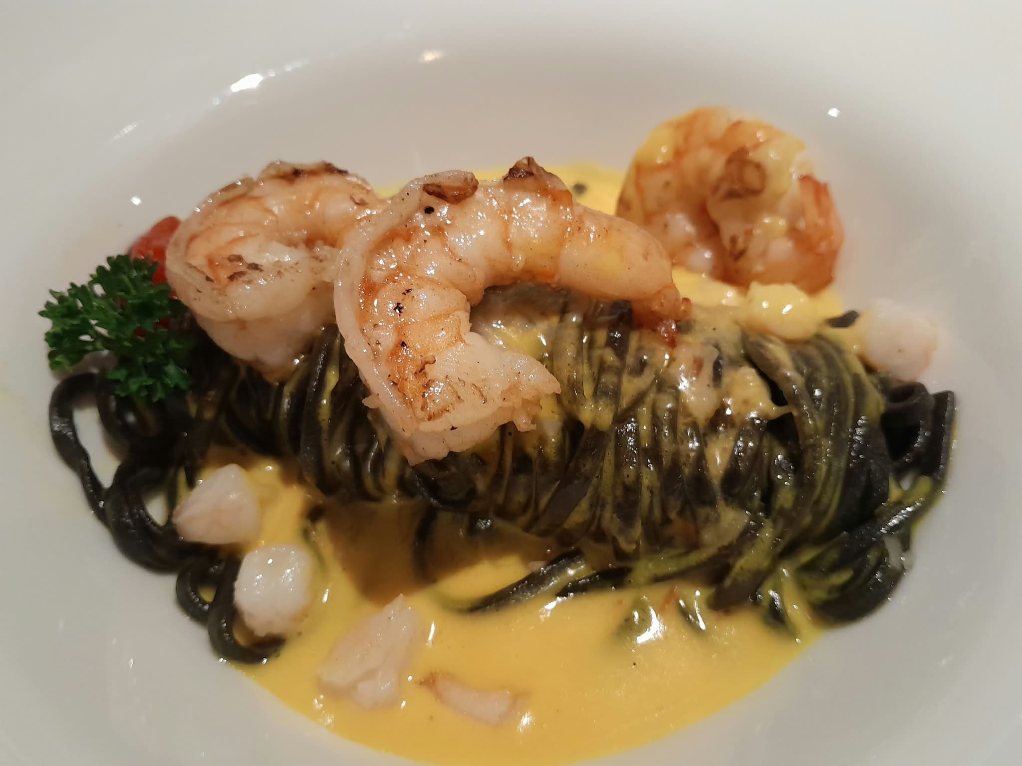 Schwarze Nudeln mit Garnelen in gelber Sauce