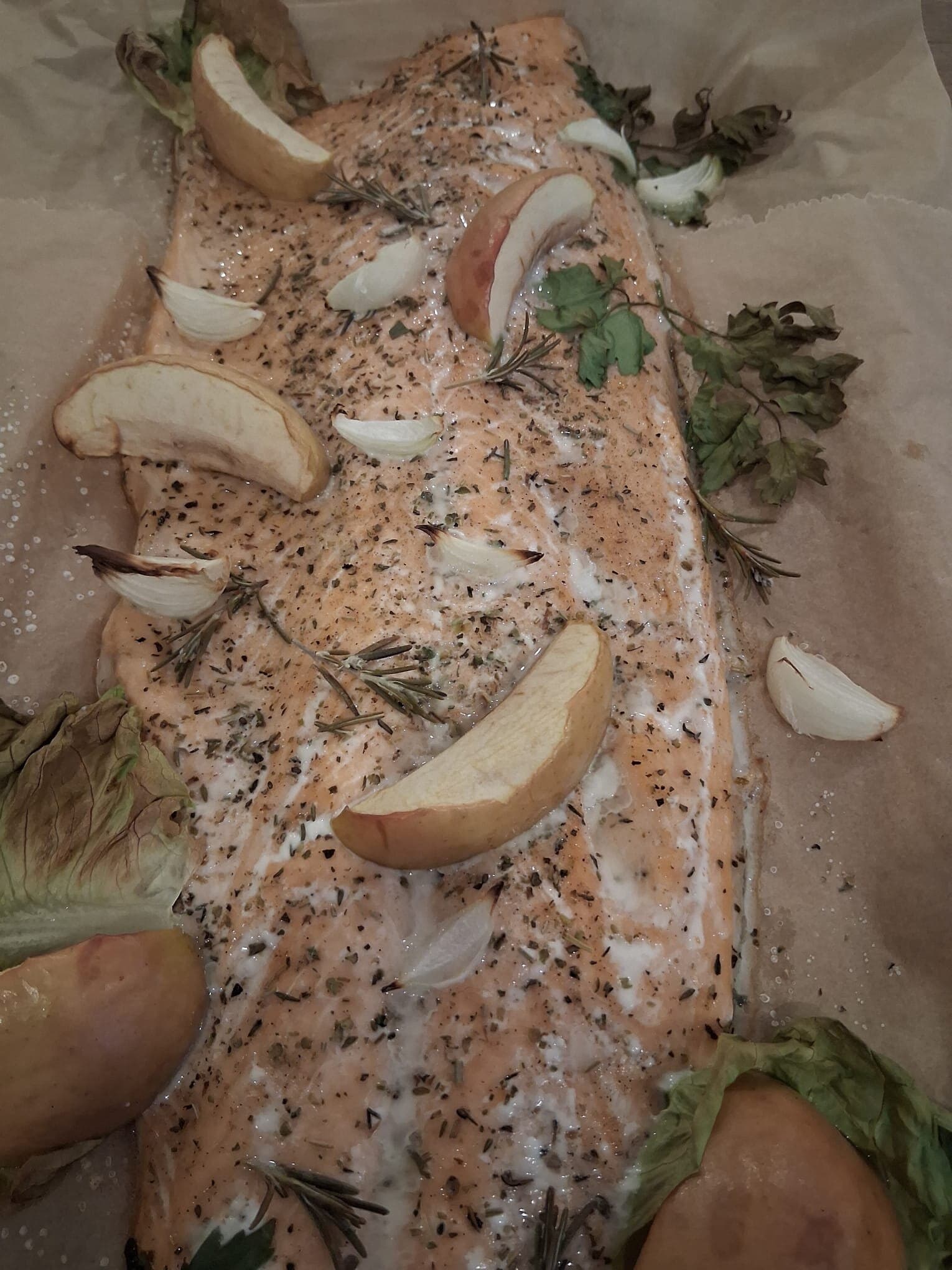 Lachs auf Backpapier mit Kräutern, Knoblauch und Apfelscheiben