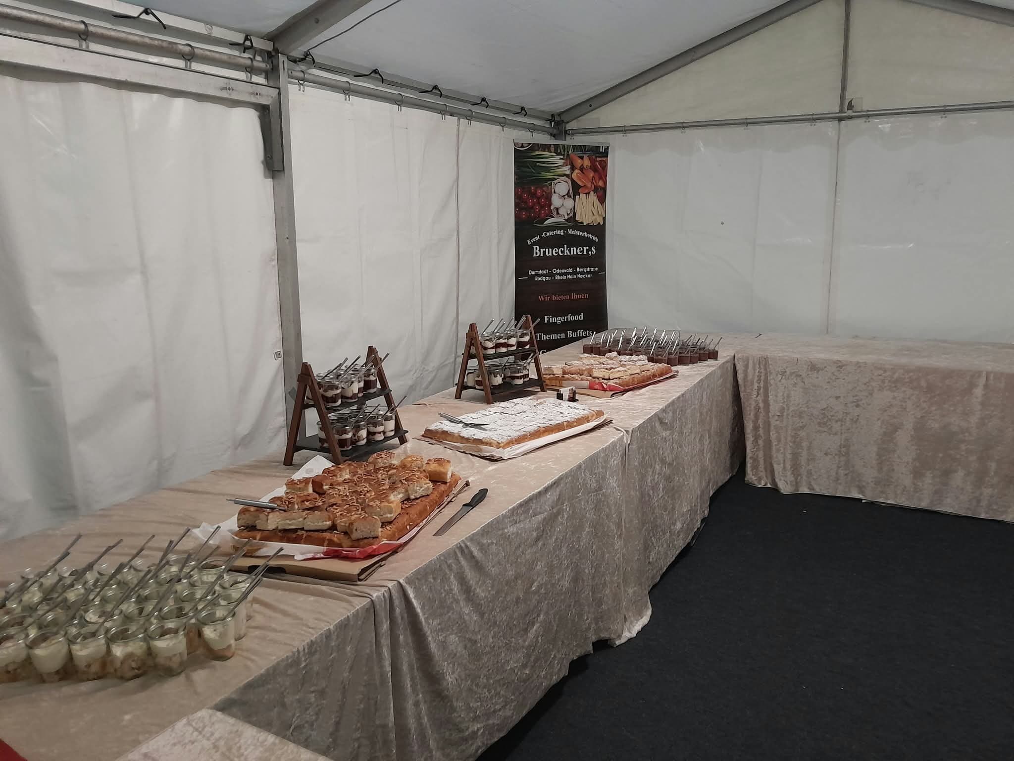 Langes Buffet in einem weissen Zelt, sein Banner im Hintergrund